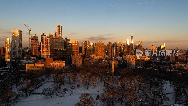 鸟瞰图的布鲁克林市中心和遥远的曼哈顿天际线在Fort Green公园覆盖在雪在阳光明媚的冬天黎明，与
监狱船烈士纪念碑的前景。